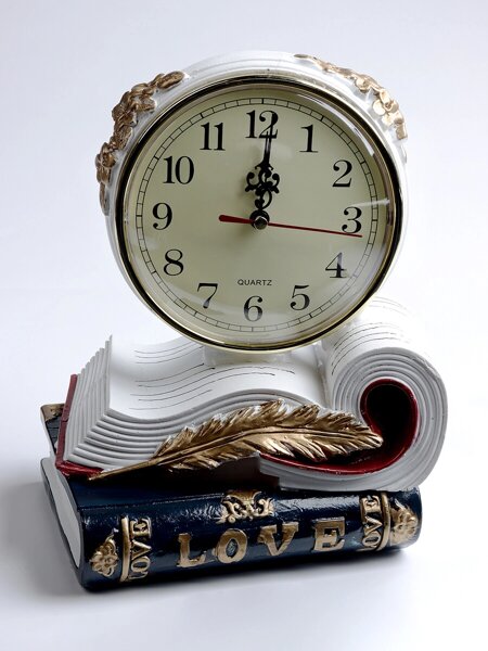 часы и книга на тумбочке